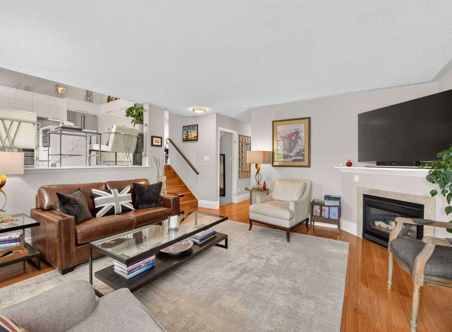 Step into this inviting living room, featuring a luxurious brown leather sofa adorned with Union Jack pillows, perfect for cozy evenings.