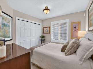 This inviting bedroom features a comfortable queen-size bed with plush bedding and decorative pillows, perfect for relaxation.