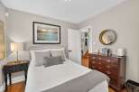 Discover this charming bedroom featuring a comfortable bed with decorative pillows and a cozy knit throw.