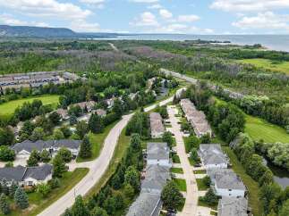 Discover this picturesque suburban neighborhood featuring a collection of modern townhouses nestled amidst lush greenery and mature trees.