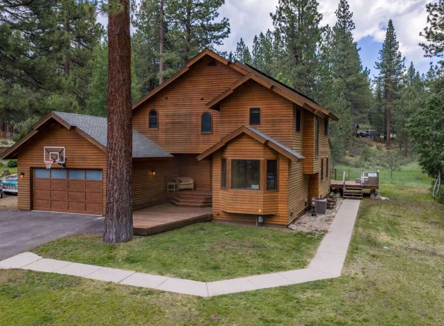 Nestled amidst tall pine trees, this charming wooden home offers a serene retreat.