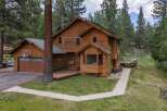 Nestled amidst tall pine trees, this charming wooden home offers a serene retreat.