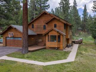 Nestled amidst tall pine trees, this charming wooden home offers a serene retreat.