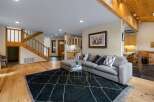 Step into this inviting living space featuring a comfortable sectional sofa adorned with decorative pillows, perfectly positioned on a stylish dark rug.