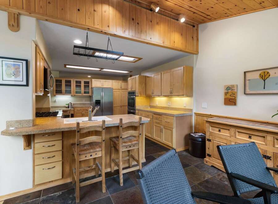 This spacious kitchen boasts beautiful light wood cabinetry and granite countertops, offering ample storage and workspace.