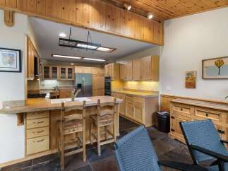 This spacious kitchen boasts beautiful light wood cabinetry and granite countertops, offering ample storage and workspace.