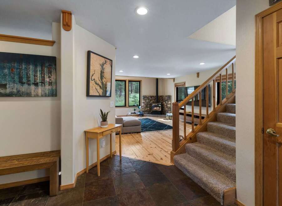 Step into this inviting entryway featuring a rustic wooden bench and a striking abstract art piece.