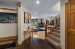 Step into this inviting entryway featuring a rustic wooden bench and a striking abstract art piece.