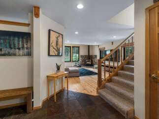 Step into this inviting entryway featuring a rustic wooden bench and a striking abstract art piece.