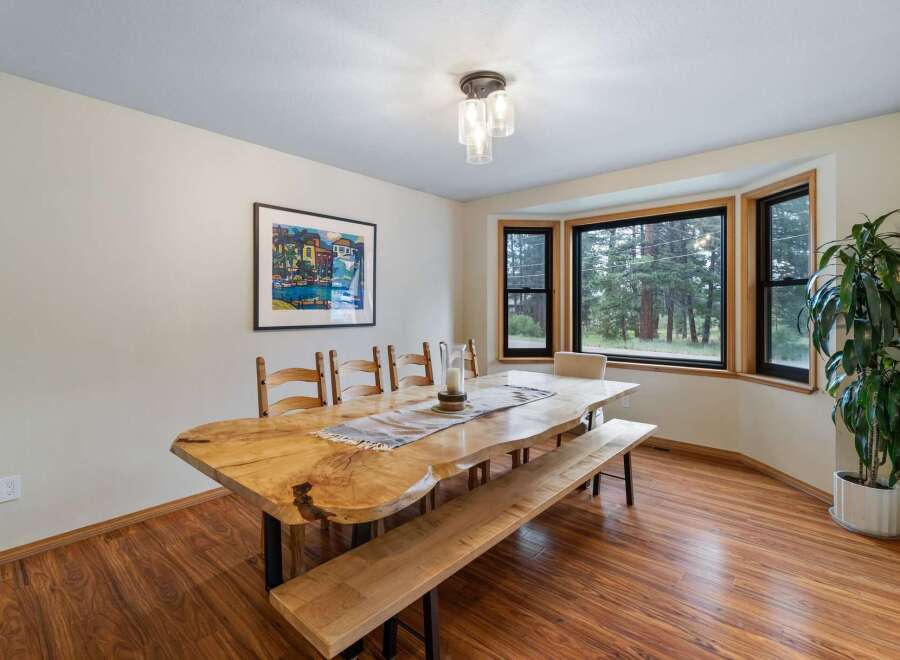 This dining room features a stunning live-edge dining table paired with a matching bench and wooden chairs, perfect for family gatherings.