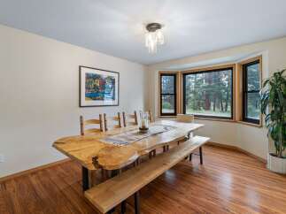 This dining room features a stunning live-edge dining table paired with a matching bench and wooden chairs, perfect for family gatherings.