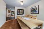 Experience elegant dining in this spacious room featuring a unique live-edge wooden table and comfortable seating.