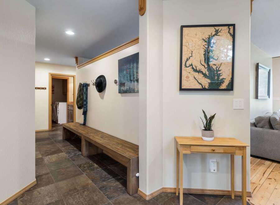 Welcome guests into this charming entryway featuring a rustic wooden bench perfect for removing shoes after a long day.