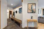 Welcome guests into this charming entryway featuring a rustic wooden bench perfect for removing shoes after a long day.