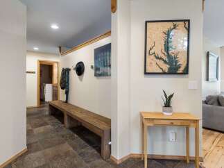 Welcome guests into this charming entryway featuring a rustic wooden bench perfect for removing shoes after a long day.