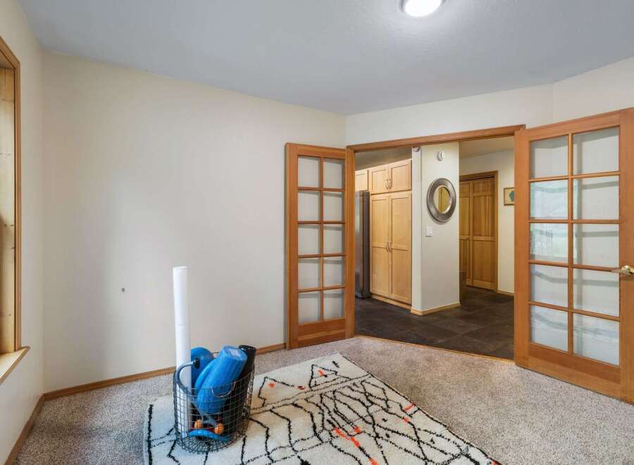 Discover a versatile space perfect for a home gym or office, featuring a large window for natural light and a cozy rug.