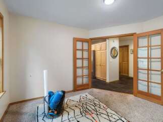 Discover a versatile space perfect for a home gym or office, featuring a large window for natural light and a cozy rug.