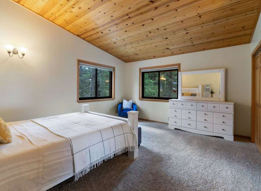 This charming bedroom features a vaulted, wood-paneled ceiling that adds warmth and character.
