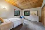 This charming bedroom features a vaulted, wood-paneled ceiling that adds warmth and character.