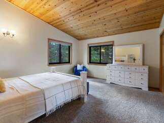 This charming bedroom features a vaulted, wood-paneled ceiling that adds warmth and character.