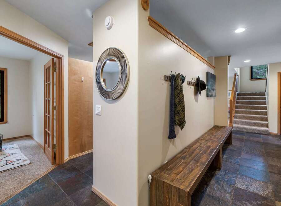 Step into a welcoming entryway featuring a rustic wooden bench perfect for removing shoes after a day outdoors.