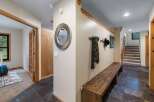 Step into a welcoming entryway featuring a rustic wooden bench perfect for removing shoes after a day outdoors.