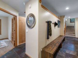 Step into a welcoming entryway featuring a rustic wooden bench perfect for removing shoes after a day outdoors.