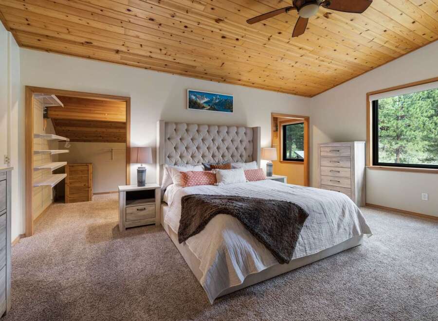 Experience ultimate comfort in this master bedroom, featuring a luxurious tufted headboard and plush carpeting.