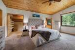Experience ultimate comfort in this master bedroom, featuring a luxurious tufted headboard and plush carpeting.