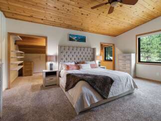 Experience ultimate comfort in this master bedroom, featuring a luxurious tufted headboard and plush carpeting.