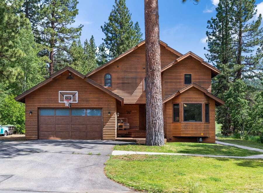 Nestled amidst tall pine trees, this charming wooden home offers a rustic retreat.