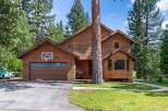 Nestled amidst tall pine trees, this charming wooden home offers a rustic retreat.