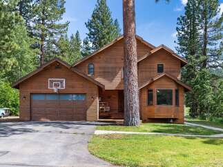 Nestled amidst tall pine trees, this charming wooden home offers a rustic retreat.