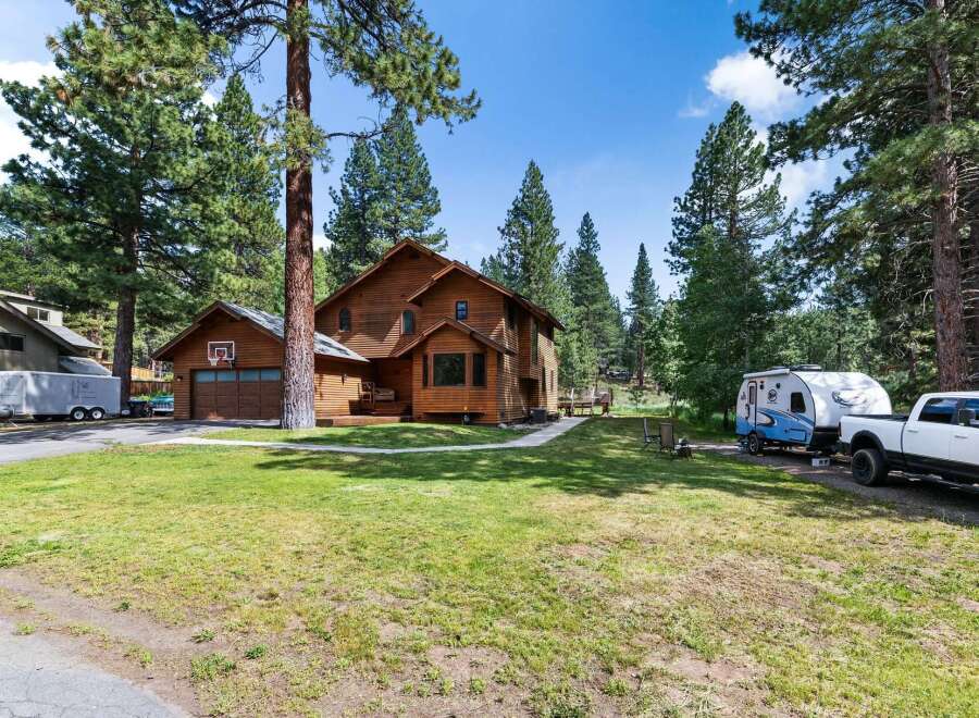 Discover this charming wooden home nestled among tall pine trees, offering a serene and private retreat.
