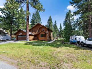 Discover this charming wooden home nestled among tall pine trees, offering a serene and private retreat.