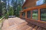 Enjoy the serene mountain lifestyle from this expansive wooden deck, perfect for entertaining or relaxing amidst the tall pine trees.