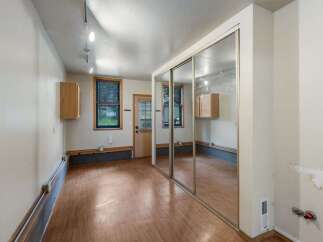 Discover this versatile space featuring a large mirrored closet, perfect for maximizing storage and creating an illusion of space.
