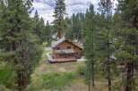 Nestled amidst tall pine trees, this charming wooden home offers a serene retreat.