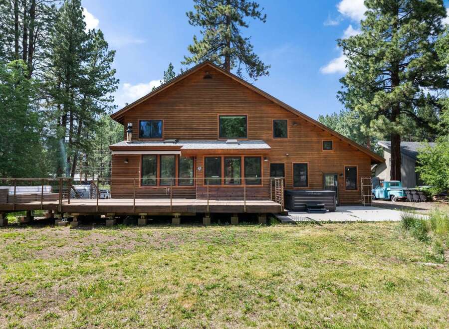 Experience the ultimate retreat in this stunning wooden home, nestled amongst tall pine trees.