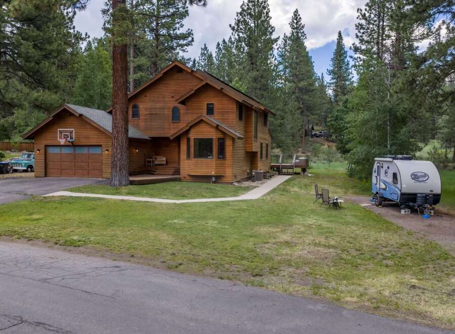 Nestled amidst tall pine trees, this charming wooden home offers a serene retreat.