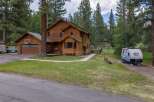 Nestled amidst tall pine trees, this charming wooden home offers a serene retreat.