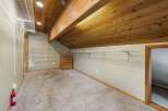 Discover ample storage in this spacious walk-in closet, featuring extensive shelving and a charming wooden dresser.