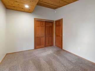 Step into this inviting room featuring a warm wooden ceiling and plush carpeting for ultimate comfort.