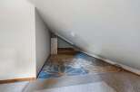 Discover versatile living space in this attic room, perfect for a home office or extra storage.