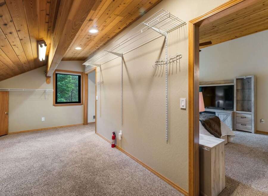Discover ample storage in this spacious room featuring a large walk-in closet with extensive shelving and hanging space.