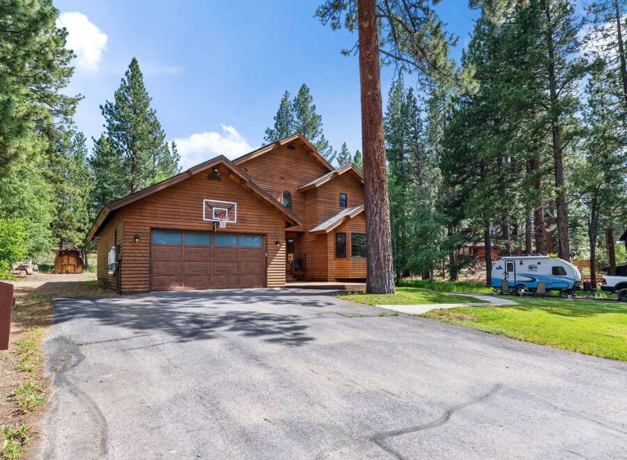 Nestled amongst tall pine trees, this charming wooden home offers a serene retreat.