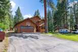 Nestled amongst tall pine trees, this charming wooden home offers a serene retreat.