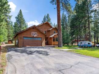 Nestled amongst tall pine trees, this charming wooden home offers a serene retreat.