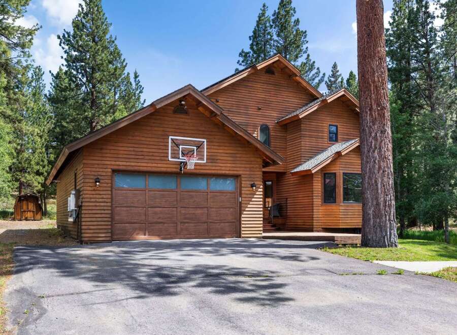 Experience mountain living in this stunning wood-sided home, perfectly nestled among tall pine trees.