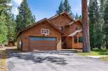 Experience mountain living in this stunning wood-sided home, perfectly nestled among tall pine trees.
